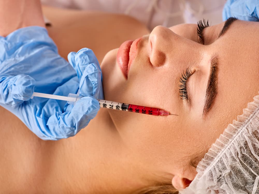 Professional application of under-eye dermal fillers with a precision syringe for facial rejuvenation and dark circle correction.