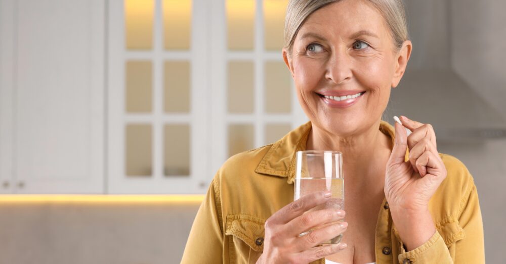 Smiling woman taking a pill